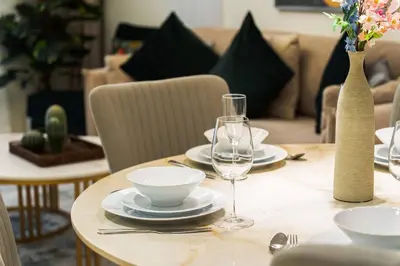 a table with plates and wine glasses on it at SettlerHomes - 14F Ocean View Gem With Private Beach in Dubai