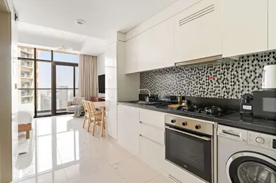 a kitchen with white cabinets and a stove at Silkhaus Studio Escape in Business Bay in Dubai
