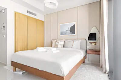 a white bedroom with a large bed and a television at Silkhaus Studio Escape in Business Bay in Dubai