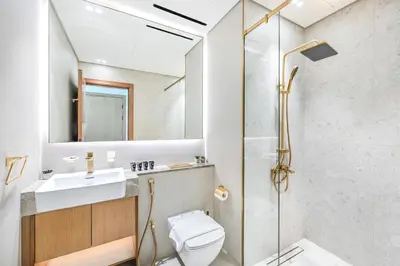 a bathroom with a shower and a toilet and a sink at Golden Stays - Private Pool in Binghatti Gardenia I Modern 2BR Escape in Dubai