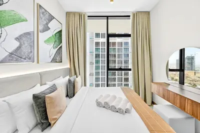 a bedroom with a white bed and a large window at Golden Stays - Private Pool in Binghatti Gardenia I Modern 2BR Escape in Dubai