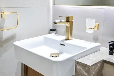 a white sink with a gold faucet in a bathroom at Golden Stays - Private Pool in Binghatti Gardenia I Modern 2BR Escape in Dubai