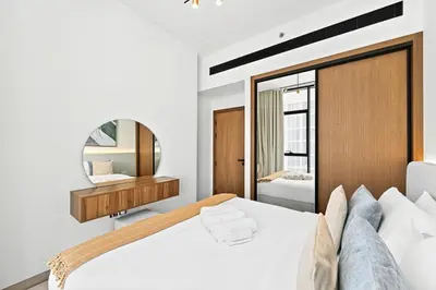 a bedroom with a large white bed and a mirror at Golden Stays - Private Pool in Binghatti Gardenia I Modern 2BR Escape in Dubai