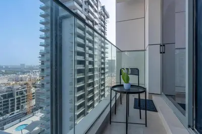 a balcony with a table and a view of a city at White Sage Modern Studio in JVC with Balcony and City Views in Dubai