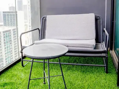 a chair and a table on a balcony at Binghatti Corner in Dubai