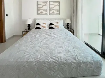 a large white bed in a bedroom with two lamps at Modern 1BR Apt in Binghatti Gardenia with Pool & Gym! in Dubai