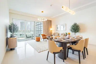 a dining room and living room with a table and chairs at Elegant 2BR, Grand Bleu, Coastal Elegance in Dubai