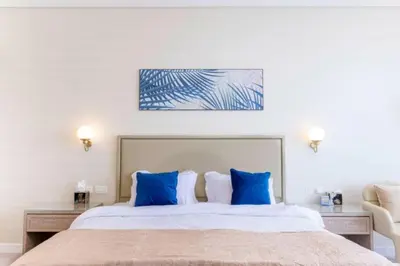 a bedroom with a large bed with blue pillows at Sky-High Elegant Suite at Palm Tower in Dubai