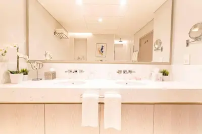 a bathroom with two sinks and a large mirror at Sky-High Elegant Suite at Palm Tower in Dubai