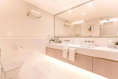 a white bathroom with two sinks and a toilet at Sky-High Elegant Suite at Palm Tower in Dubai