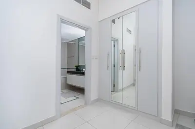 a white bathroom with a walk in shower and a mirror at High-Floor Elegance | 1-Bedroom with Marina Views in Dubai