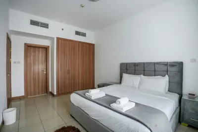 a bedroom with a large bed with two towels on it at Stylish 1BHK in Sulafa Tower at Dubai Marina in Dubai