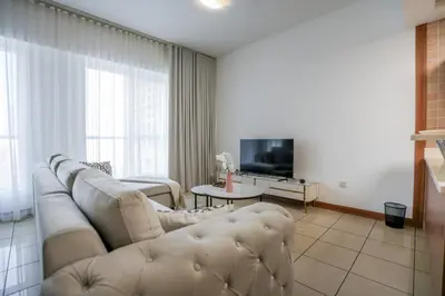 a living room with a couch and a tv at Stylish 1BHK in Sulafa Tower at Dubai Marina in Dubai