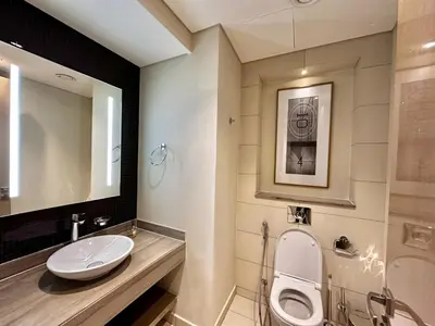 a bathroom with a sink and a toilet and a mirror at Luxury 1BHK in Damac Paramount Towers, Business Bay in Dubai