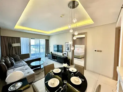 a living room with a dining table and a couch at Luxury 1BHK in Damac Paramount Towers, Business Bay in Dubai