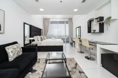 a large living room with a bed and a desk at Sleek and Spacious Sports City Studio in Dubai