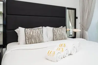 a bedroom with a large white bed with two pillows at Sleek and Spacious Sports City Studio in Dubai
