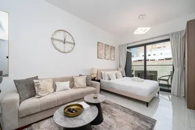 a living room with a couch and a bed at Stylish Studio in JVC Bright, Cozy and Convenient in Dubai