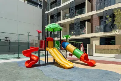 a playground with a slide in front of a building at Modern JVC 1-Bed Pool, Gym and Family Amenities in Dubai