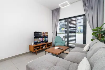 a living room with a couch and a tv at Modern JVC 1-Bed Pool, Gym and Family Amenities in Dubai