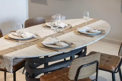 a table with chairs and wine glasses on it at Boho Comfort - 1BR with Gym, Pool, Tennis, Yoga and Dubai Mall access in Dubai