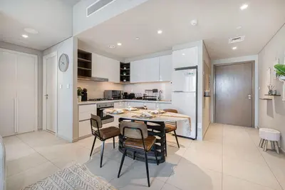 a kitchen and dining room with a table and chairs at Boho Comfort - 1BR with Gym, Pool, Tennis, Yoga and Dubai Mall access in Dubai