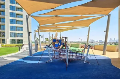 a table and chairs under an umbrella on a patio at Boho Comfort - 1BR with Gym, Pool, Tennis, Yoga and Dubai Mall access in Dubai