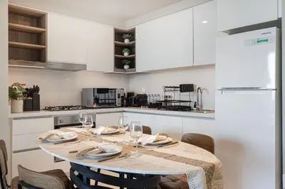 a kitchen with a table with wine glasses on it at Boho Comfort - 1BR with Gym, Pool, Tennis, Yoga and Dubai Mall access in Dubai