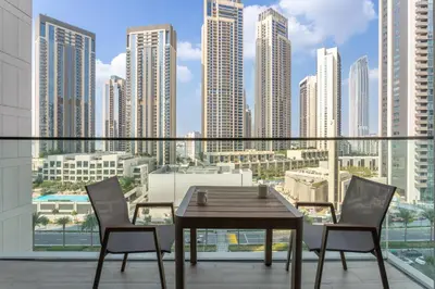 a table and chairs on a balcony with a view of a city at Vacationer Chic 1 Bedroom Creek Harbour in Dubai