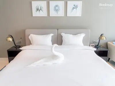 a white swan sitting on a white bed at Luxury 1BHK Apartment at DAMAC Prive A, Business Bay in Dubai
