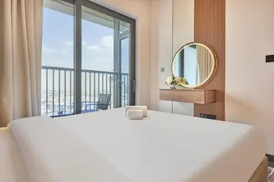 a bedroom with a white bed and a large window at STAY BY LATINEM Luxury 1BR Holiday Home CB 2001 Near Burj Khalifa in Dubai