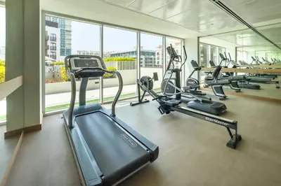 a gym with several treadmills and elliptical machines at Contemporary 1Bedroom Escape in Eaton Place in Dubai