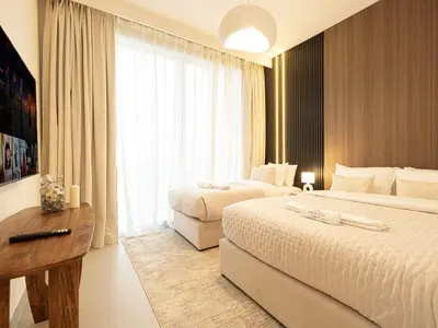 a hotel room with two beds and a desk at Forte Suites by Prestige Nest in Dubai