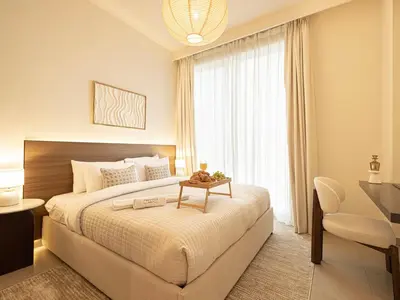 a bedroom with a large bed with a table on it at Forte Suites by Prestige Nest in Dubai