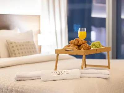 a tray of breakfast foods and a glass of orange juice on a bed at Forte Suites by Prestige Nest in Dubai