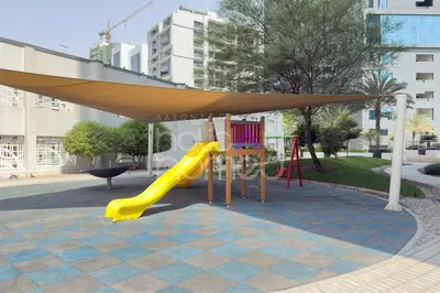 a playground with a yellow slide and a canopy at Elegant Studio apartment in Avanti Tower Business Bay in Dubai