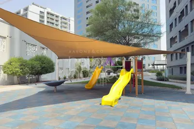 a playground with a yellow slide and a canopy at Elegant Studio apartment in Avanti Tower Business Bay in Dubai