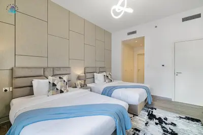 two beds in a room with white walls at Cozy 2-BR at Belgravia Square in Dubai