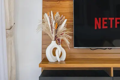 two white vases sitting on a table next to a tv at Cozy 2-BR at Belgravia Square in Dubai