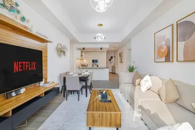 a living room with a couch and a tv at Cozy 2-BR at Belgravia Square in Dubai