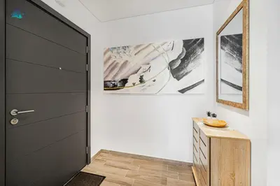 a hallway with a black door and a wooden cabinet at Cozy 2-BR at Belgravia Square in Dubai