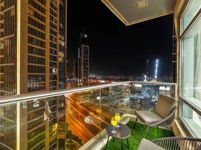 a balcony with a view of a city at night at Luxury Stay in Downtown-Steps to Burj & Dubai Mall in Dubai