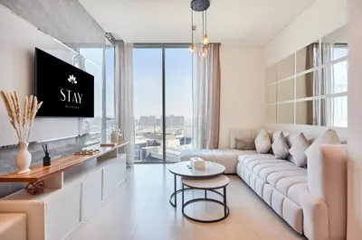 a living room with a large couch and a tv at STAY BY LATINEM Luxury 1BR Holiday Home CVR A511 near Downtown in Dubai