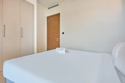 a white bed in a room with a door at STAY BY LATINEM Luxury 1BR Holiday Home CVR A511 near Downtown in Dubai