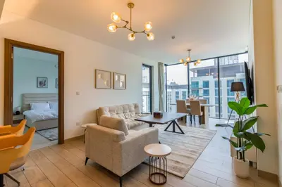 a living room with a couch and a table at One Park Avenue, Sobha Hartland 3 BR in Dubai