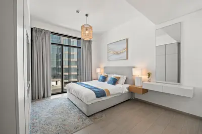 a bedroom with a bed and a large window at One Park Avenue, Sobha Hartland 3 BR in Dubai