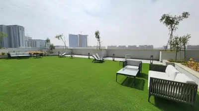 a rooftop patio with green grass and benches on a building at STAY BY LATINEM Luxury 1BR Holiday Home CVR B 602 near Downtown in Dubai