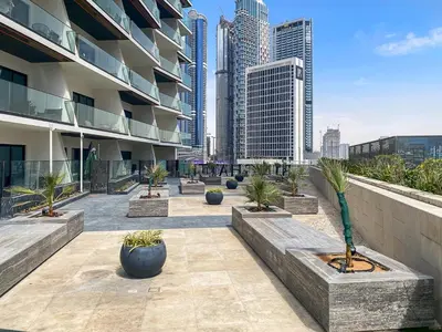 a building with a courtyard with potted plants and buildings at Burj Khalifa View 2BR at Binghatti Canal in Dubai