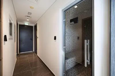 a hallway with a glass door to a walk in shower at Park Views by Samana with Private Pool in Dubai