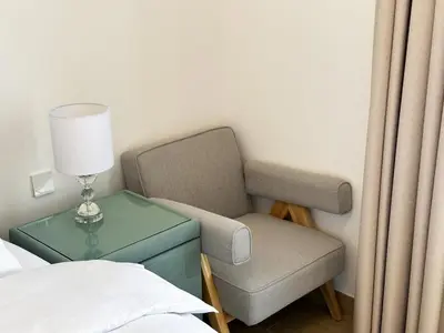 a bedroom with a chair and a table with a lamp at NYE Firework View - Beachfront Residence - Sea View in Dubai